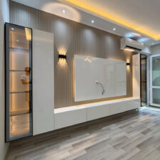 Τοίχος επενδεδυμένος με κάθετα πηχάκια, πλαισιωμένος από ντουλάπια βάσης ή βιτρίνες αποθήκευσης.